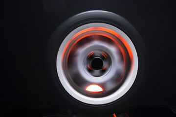 long exposure photography in motion spinning car titanium rims in blurry light	