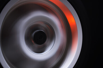 long exposure photography in motion spinning car titanium rims in blurry light	