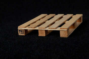 Reduced model wooden euro pallet on black felt background....