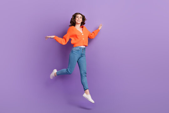 Full length photo of positive cheerful active energetic lady move empty space good mood enjoy free time isolated on purple color background