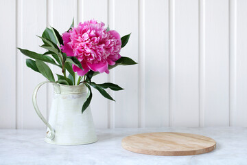 pink peony and cutting board on the table, place for your object or text.