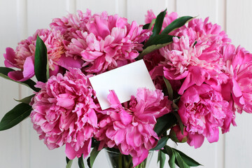 bouquet of pink peonies in close-up and an empty business card. mockup, scene creator.