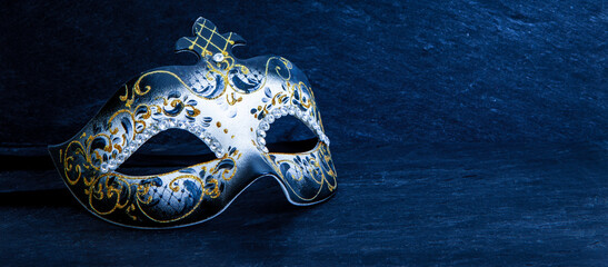 Festive Venetian carnival mask with gold glitter decorations and diamond beads on dark blue background. - obrazy, fototapety, plakaty