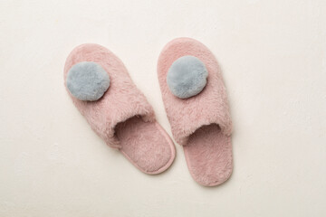 Fototapeta na wymiar Soft pink slippers on color background, top view
