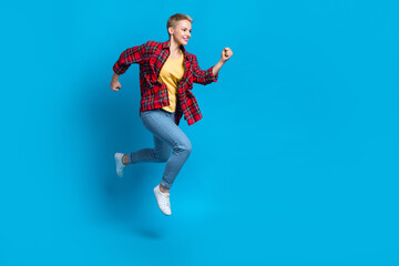 Fototapeta premium Full body length photo of youngster funky girl running jumping hurry wear stylish casual outfit clothes brand isolated on blue color background