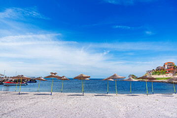 Straw beach umbrellas and sun loungers for relaxing by the sea.