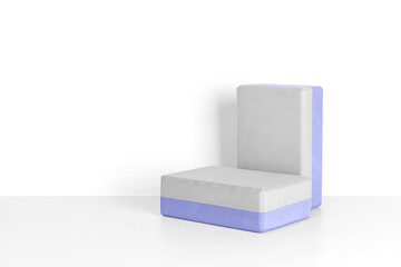 Two yoga blocks on a gray background, front view. A podium of blocks to showcase sports accessories. Fitness and activity. 
