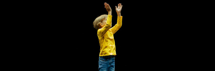 cute happy candid caucasian little six year old kid boy with long blonde hair stands tall full...