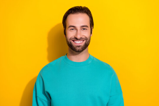 Photo portrait of young positive smile brunet hair attactive student guy wear blue jumper enjoy his freelance job isolated on yellow color background