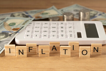 The word INFLATION on wooden cubes on a wooden background in the idea for the FED to consider raising interest rates, the world economy and the fight against inflation, U.S. dollar inflation