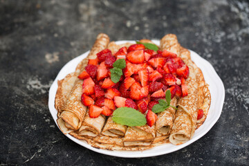 Delicious pancakes with fresh strawberries on a metal background