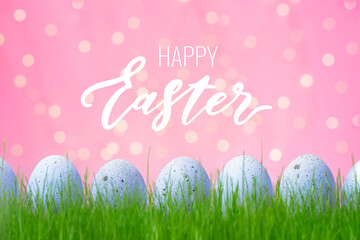 Concept of Easter egg hunt on pink background. Decorated lilac eggs in grass. Web banner or flyer with Happy Easter lettering.