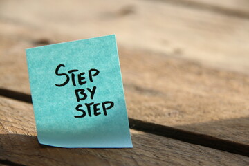 Step by step. Motivational quotes. The inscription on the blue tag.