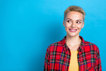 Fototapeta premium Closeup portrait of cheerful satisfied short blonde hairstyle lady wear red plaid shirt look empty space new brand isolated on blue color background