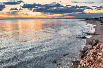 tramonto in spiaggia visto dal drone, con le nuvole riflesse nell'acqua - marina di Lizzano, Puglia, Salento, Taranto, Italy
