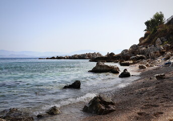 Fototapeta na wymiar View of the sea splashing into rocks and stones near the coast