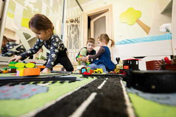 Child leisure activity, creative game. Kids play at home with toy train.