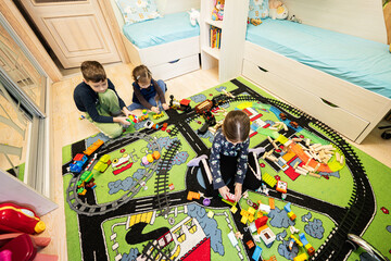 Child leisure activity, creative game. Kids play at home with toy train.