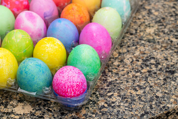 Dyed Easter eggs sit on a granite counter top to dry
