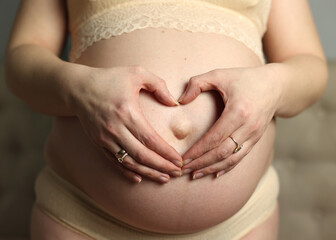 Pregnant woman in underwear. She is 30 weeks pregnant and has a big belly. Expecting a child. Third pregnancy