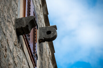 Stone details of pulley fixed on facade of old, stone house in Dalmatia, used for pulling furniture and heavier objects inside