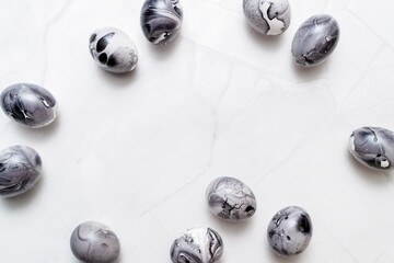 Eggs painted marble on white background. Minimal Easter concept with space for text. Black monochrome luxury backdrop.