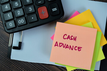 Concept of Cash Advance write on sticky notes isolated on Wooden Table.
