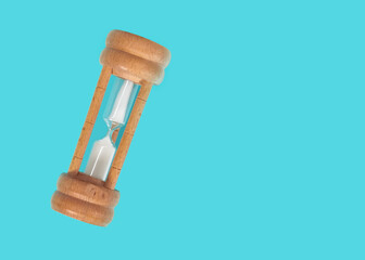 Old wooden hourglass isolated on Cyan background.