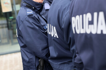 Zimowy mundur policjanta z napisem policja na plecach.  - obrazy, fototapety, plakaty
