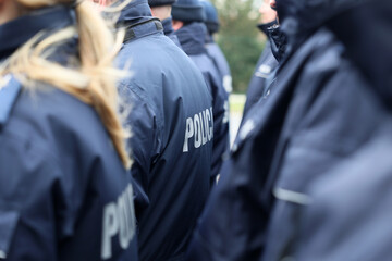 Zimowy mundur policjanta z napisem policja na plecach. 