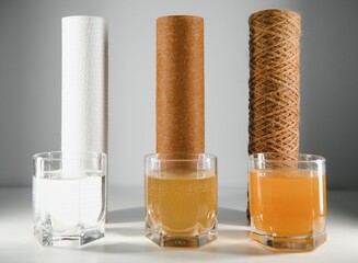 Filter system for water treatment with glasses of clean and dirty water on bright background