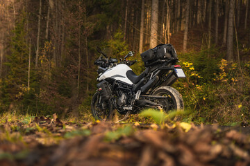 Triumph Tiger motorcycle on the forest road in mountains