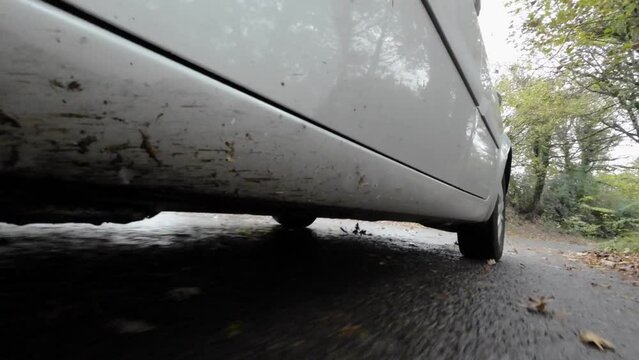 Abstract view of a silver car driving on a rural road