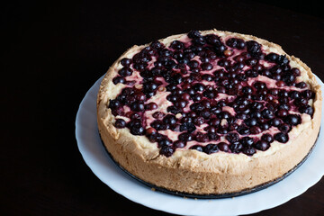freshly baked berry pie on dark background, close-up, dessert with fresh fruit, hot, steaming