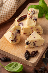 Close up cheese slices with berries. Rustic background, vertical image