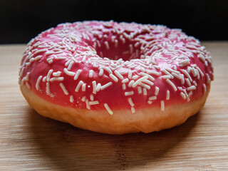 Pink tasty donut on the bamboo table