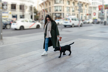 Naklejka premium Young woman walking with the dog