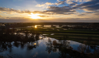Sunset over flooded fields. Sunset reflection in submerged fields. Submerged fields. Afternoon sun reflection in submerged fields.