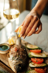 Proper way to eat fish. Squeezing a lemon on a fish.