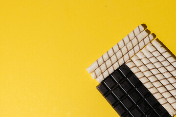 Happy Valentine's day. Dark chocolate. Sweet tubes on a yellow background. Copy space.