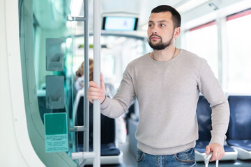 Fototapeta na wymiar Portrait of male passenger in tram car on a spring day