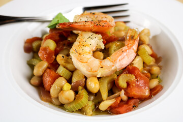 A homemade dish of fresh shrimp, beans, garlic, and sage.