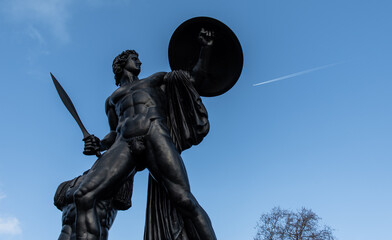 Obraz premium London, UK - 2023: 18ft statue of Achilles, the Greek hero of the Trojan War commemorating the soldier and politician, Arthur Wellesley near the Queen Elizabeth Gate at Hyde Park Corner. 