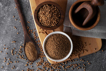 Coriander grains and coriander powder in a wooden bowl. Coriander seeds. Coriander spice.