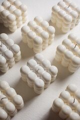 A pastel yellow bubble candle on a white background 