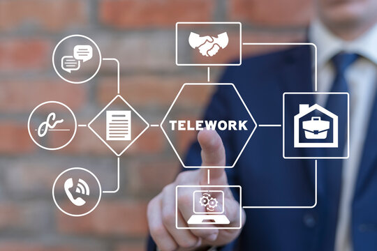 Businessman using virtual touchscreen presses word: TELEWORK. Concept of telework. Teleworking, remote work or telecommuting, freelance workers, workers at home.