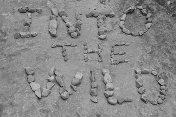 Letters made of individual stones along a hiking trail with the phrase: Into the wild