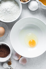 Organic raw eggs in a white mixing bowl for baking and cooking