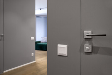Close up shot of modern double black light switch on edge of grey wall in living room