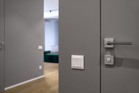 Close up shot of modern double black light switch on edge of grey wall in living room - Powered by Adobe